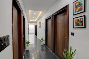 FabHotel Groom Room في نويدا: ممر مع بابين والنباتات الفخارية