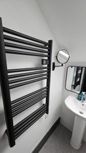 a bathroom with a mirror and a sink at Tommy Jacks Beach Apartments in Bude +95 photos