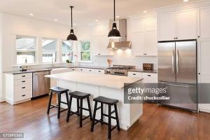 eine Küche mit weißen Schränken und eine große Insel mit Barhockern in der Unterkunft Luxury studio to stay 5 and view in Ruse