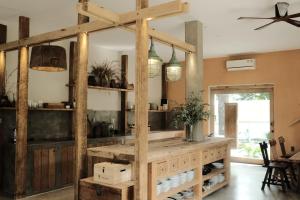 Una cocina con estantes de madera y luces colgantes. en Nong Lam Ecolodge, en Linh Xuân Thôn