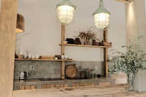 Una cocina con estantes de madera y dos luces. en Nong Lam Ecolodge, en Linh Xuân Thôn