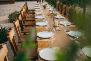 una larga mesa de madera con platos blancos y copas de vino en Nong Lam Ecolodge, en Linh Xuân Thôn 75 fotos más