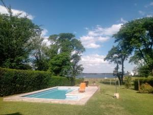 a swimming pool in a yard next to the water at Casa La Escondida in Villa del Dique