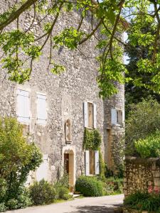 Gîte du Puy Drome Provençale Puygiron في Puygiron: مبنى حجري قديم بباب واشجار +8 صور