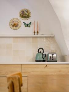 Gîte du Puy Drome Provençale Puygiron في Puygiron: طاولة مطبخ مع صحون وغلاية شاي