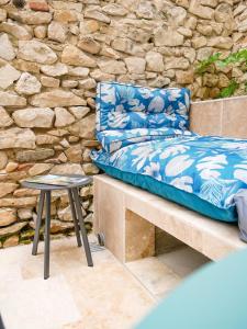 Gîte du Puy Drome Provençale Puygiron في Puygiron: كرسي موضوع على مقعد بجوار جدار حجري