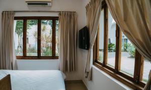 a bedroom with two beds and a window at Nong Lam Ecolodge in Linh Xuân Thôn
