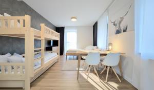 a bedroom with a bunk bed and a table and chairs at Javorná - Aura a Nord in Čachrov +10 photos