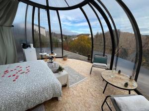 a bedroom with a bed and a large window at Entre Ciel et Rivière in Bouillon +15 photos