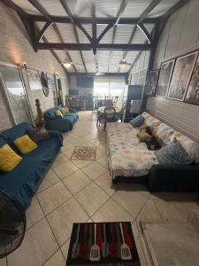 a living room with couches and a room with at Maison charmante à Fort-de-France avec équipements modernes in Fort-de-France