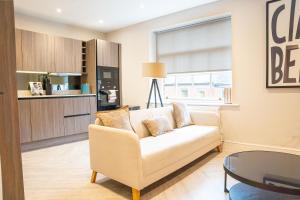 a living room with a couch and a table at 10 Park Square East, Luxury Serviced Apartments in Leeds