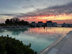a large swimming pool with a sunset in the background at Remida Managed By Dedeman in İntepe
