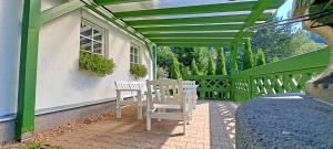a green pergola with two benches on a patio at Domek Markoušovice in Velké Svatoňovice +10 photos