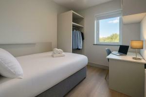 a bedroom with a bed and a desk with a laptop at Refurbed 4BDR Home on Dock Road Near City Centre in Limerick