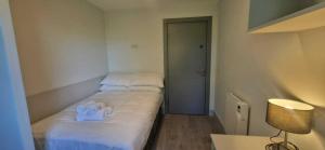 a small bedroom with a bed with white sheets at Refurbed 4BDR Home on Dock Road Near City Centre in Limerick