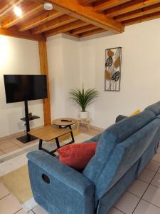 a living room with a blue couch and a tv at Appartement 3 Chambres Bollezeele in Bollezeele