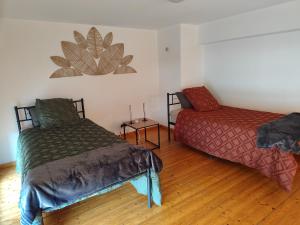 a room with two beds and a chair in it at Appartement 3 Chambres Bollezeele in Bollezeele