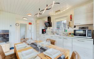 una cucina con tavolo da pranzo e una cucina con forno a microonde di Onkel Toms Hütte a Wandlitz