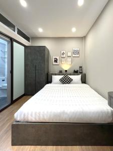 um quarto com uma cama grande com lençóis brancos em The Indochina Homestay and Travel by Nguyen em Hanói mais 12 fotografias