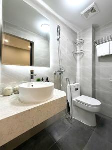 um banheiro com uma pia, um vaso sanitário e um espelho em The Indochina Homestay and Travel by Nguyen em Hanói