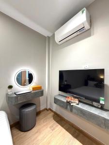 uma sala de estar com uma televisão grande e um sofá em The Indochina Homestay and Travel by Nguyen em Hanói