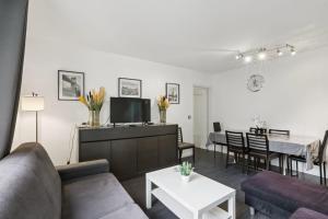 una sala de estar con un sofá y una mesa en Superbe 90M2, chic & cosy avec Parking privé et Terrasse - 10pers, en Villeurbanne