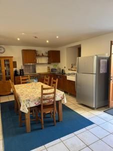 a kitchen with a table and a refrigerator at Grange des Taouré in Vignec