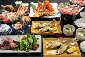 a table topped with plates of food with fish at Sunhills Sarai in Shintotsukawa