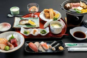 a table topped with plates of sushi and other food at Sunhills Sarai in Shintotsukawa +18 photos
