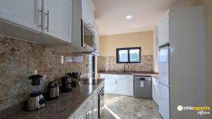 a kitchen with white cabinets and a counter top at Chic & spacious studio with parking in Yaoundé