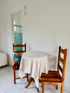 a table and two chairs with a white table cloth at Mandacaru Pousada Arraial D'Ajuda in Arraial d'Ajuda