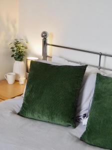 ein Bett mit zwei grünen Kissen darauf in der Unterkunft Modern & Spacious 2-bed flat - Central Cardiff - Fast Wifi - Long & Short Stay in Cardiff