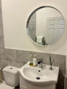 ein Badezimmer mit einem weißen Waschbecken und einem Spiegel in der Unterkunft Modern & Spacious 2-bed flat - Central Cardiff - Fast Wifi - Long & Short Stay in Cardiff + 15 Fotos