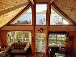 an attic room with large windows and a couch at Holiday home- 50m to sandy beach at Kavlanda Brygga SE09147 in Tviklippan