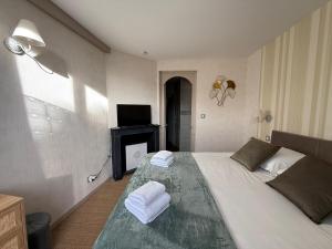 een slaapkamer met een bed met handdoeken erop bij L'Evasion Troyenne T21 in Troyes