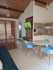 a kitchen with a table and blue chairs in a room at Solar Águas Pipa Stays in Pipa