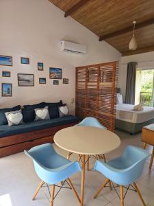 a living room with a couch and a table and chairs at Solar Águas Pipa Stays in Pipa