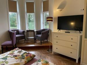 a living room with a tv and a dresser with a dresser at Villa Deichvoigt in Cuxhaven