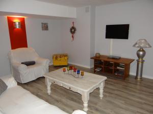 a living room with a coffee table and a tv at Aux oiseaux de passage in Rosheim