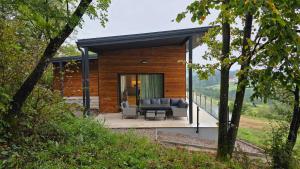 a small house with a couch and a patio at Forest Edge Lake House in Desmerice