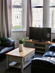 ein Wohnzimmer mit Fernseher und Couchtisch in der Unterkunft Modern & Spacious 2-bed flat - Central Cardiff - Fast Wifi - Long & Short Stay in Cardiff