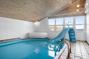een binnenzwembad met een glijbaan in een huis bij 941-Thisted-Klitstien-37 in Torsted