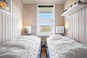 een slaapkamer met twee bedden en een raam bij 941-Thisted-Klitstien-37 in Torsted +17 foto's