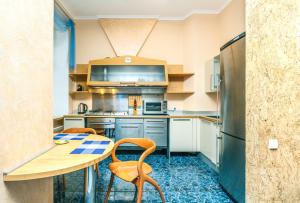 a kitchen with a table and chairs and a refrigerator at Three bedroom, 8 Lyuteranska str, Centre of Kiev in Kyiv