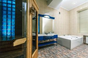 a bathroom with a tub and a sink and a bath tub at Three bedroom, 8 Lyuteranska str, Centre of Kiev in Kyiv +16 photos