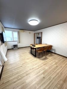 een grote kamer met een tafel en stoelen. bij Frasis in Furano