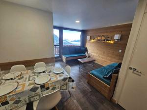 een woonkamer met een tafel, stoelen en een bank bij Appartement rénové et tout confort · Au cœur de la station · Animaux admis - FR-1-181-906 in Plagne Bellecote