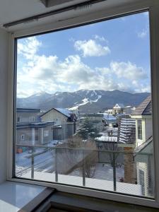 uitzicht op een besneeuwde berg vanuit een raam bij Frasis in Furano