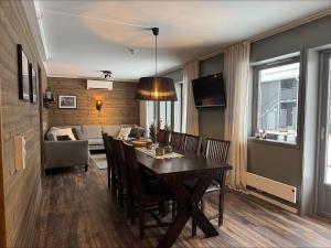 Vasabyn Fjällnära - Lindvallen - Ski in Ski out في سالن: غرفة طعام وغرفة معيشة مع طاولة وكراسي