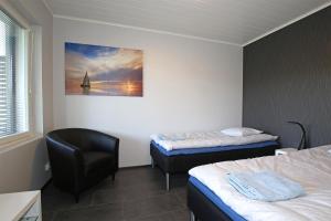 a hotel room with two beds and a chair at Amiraali in Jämsä